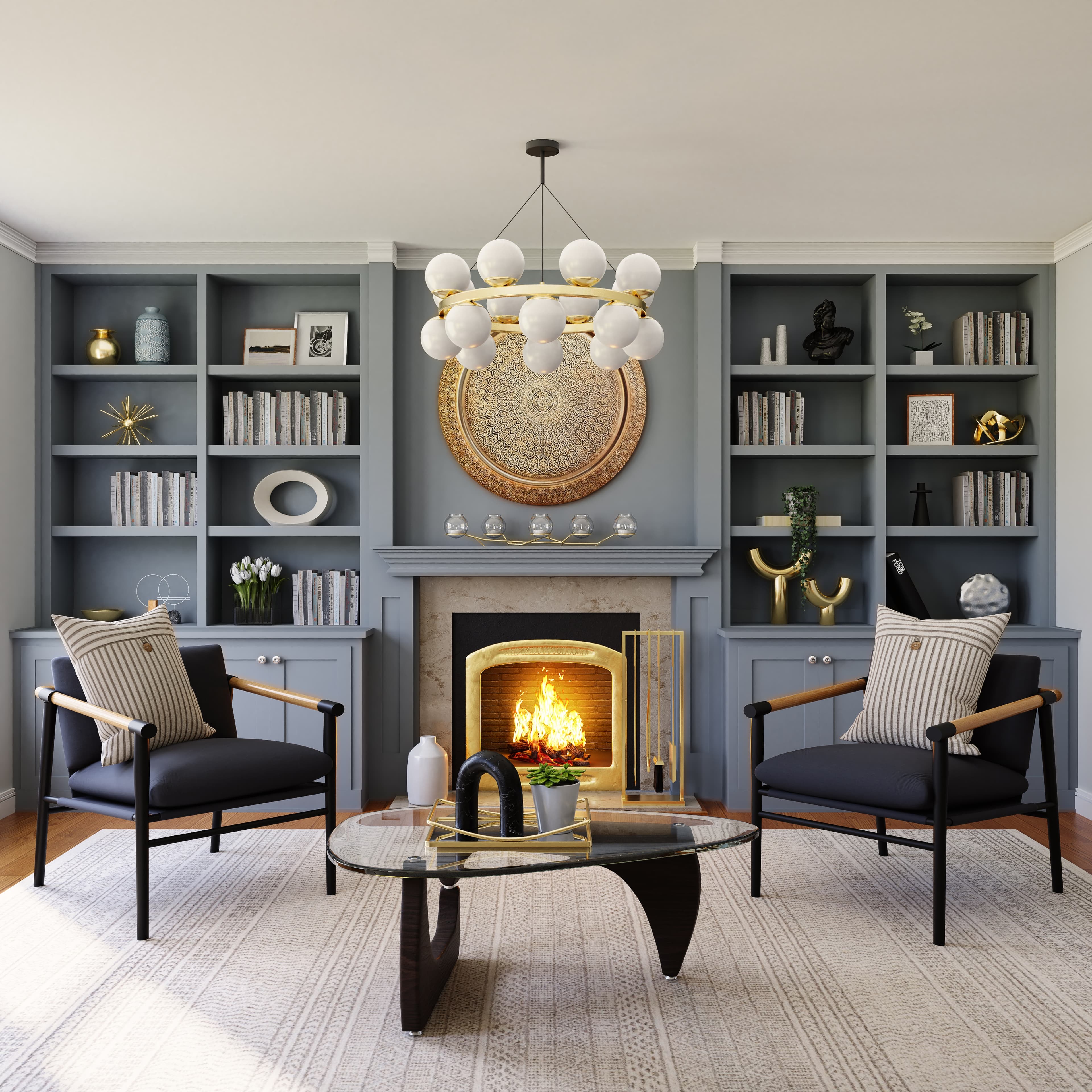 Modern style sitting room with 2 minamilist arm chairs facing towards a glass coffee table. There are pastelle gray wells and a ornamental metalic art piece above the fireplace. There are various books and sculptures in the display openings of the display unit.